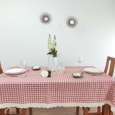 Mesa posta com toalha xadrez vermelha e branca e decoração minimalista