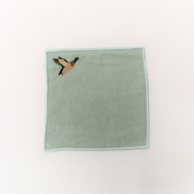 Guardanapo verde claro com bordado de pato voando no canto