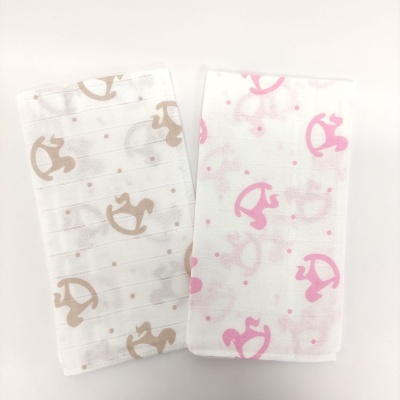 Duas toalhas de pano com padrão de cavalos de baloiço em castanho e rosa