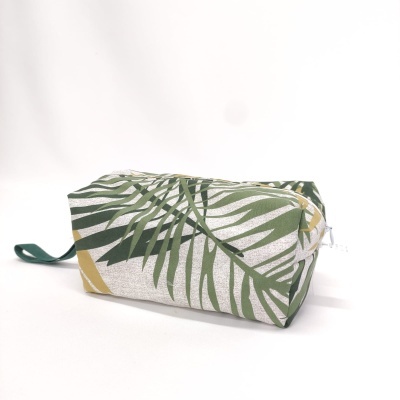 Estojo rectangular com padrão de folhas verdes e amarelas e fecho branco