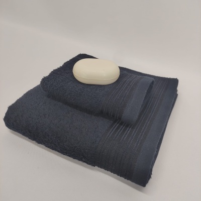 Toalhas azul escuras dobradas com sabonete branco em cima
