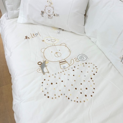 roupa de cama branca com desenho bordado de urso, pássaro e formiga, texto 'hello'
