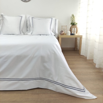 Conjunto de roupa de cama branco com linhas azuis em padrão geométrico simples