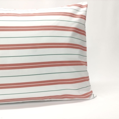 Almofada retangular com riscas laranja e verde sobre fundo branco