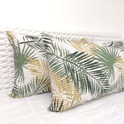 Almofadas com padrão de folhas verde e bege sobre fundo branco