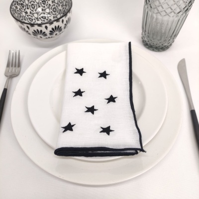 Conjunto de louça com prato, guardanapo com estrelas, tigela e copo em fundo branco