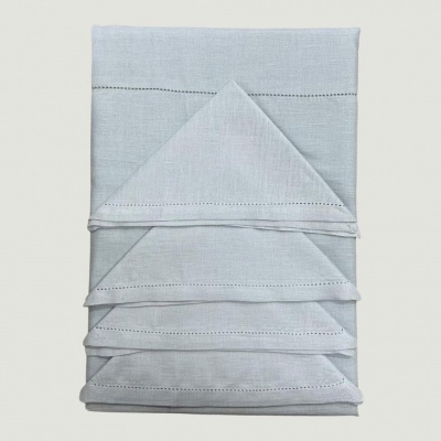 Guardarapos de linho branco com bainha decorativa preta dobrados