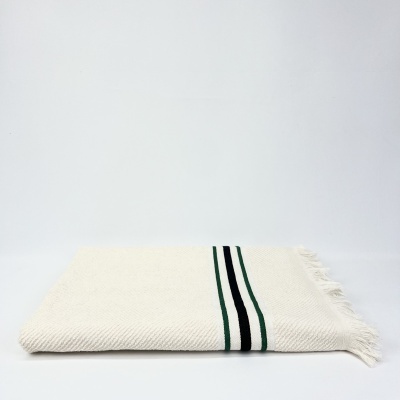 Manta branca com franjas e riscas verticais em verde e preto