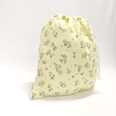 Saco de tecido amarelo com flores pequenas e cordão branco