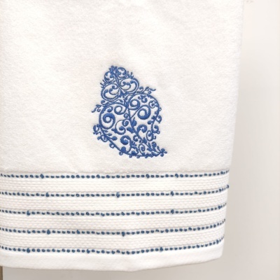 Toalha branca com bordado azul ornamental e riscas horizontais azuis