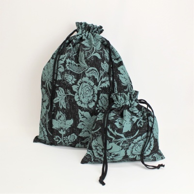 Dois sacos de tecido azul escuro e preto com padrão floral e cordão preto, um maior e outro menor