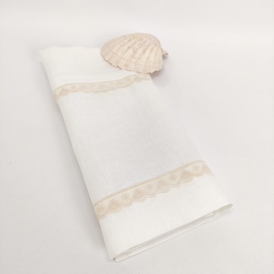 Guardanapo branco bordado com concha clara em superfície branca