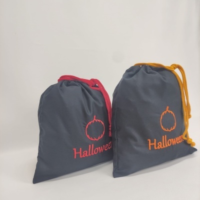Dois sacos de tecido pretos com desenhos de abóboras e a palavra Halloween bordadas em cores diferentes