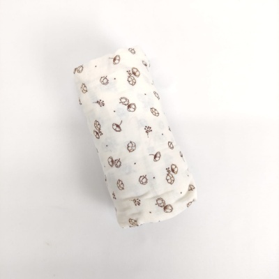 Manta branca com padrão de flores castanhas enrolada sobre fundo branco