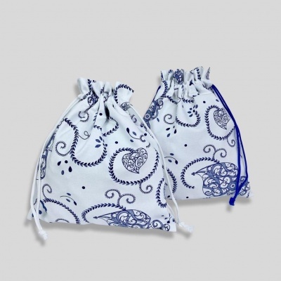 Dois sacos de pano branco com padrão azul e cordões de fecho