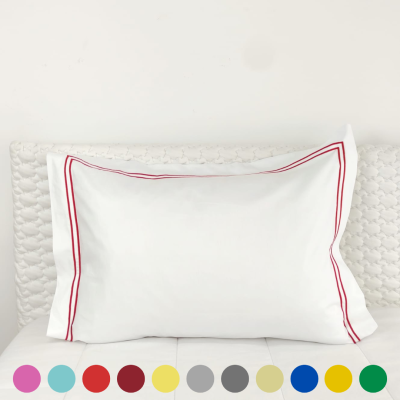 Travesseiro branco com bordado vermelho e base texturizada bege claro