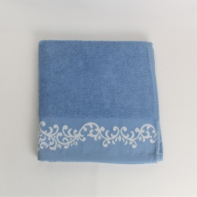 Toalha azul com decoração branca sobre superfície branca