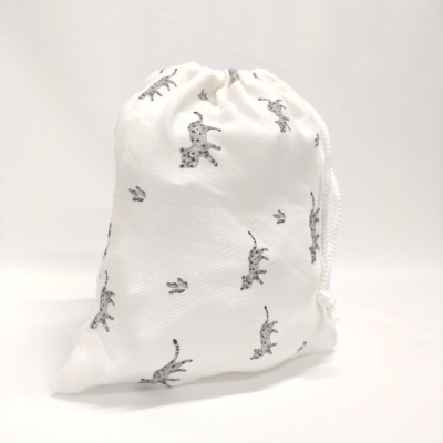 Saco branco com padrão de girafas cinzentas e pegadas pretas com fecho de cordão