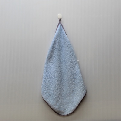 Toalha azul de felpa pendurada numa parede cinzenta