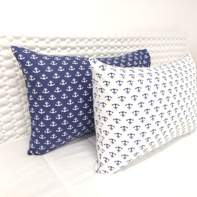 Duas almofadas retangulares com padrão de âncoras num fundo azul e branco