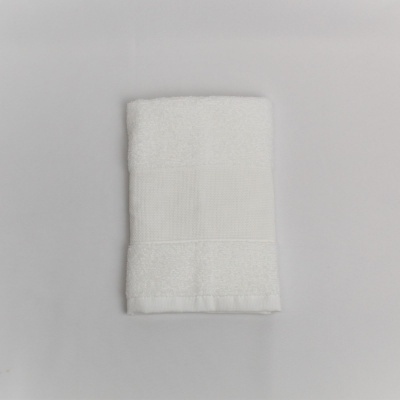 Toalha branca de algodão dobrada sobre fundo cinzento