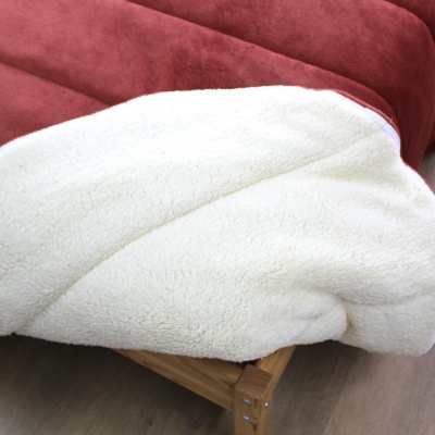 cobertor vermelho com lado branco felpudo sobre suporte de madeira