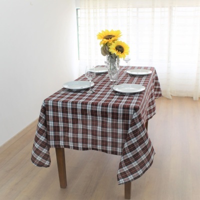 Mesa com toalha xadrez e arranjo de girassóis