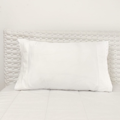 Travesseiro branco com fronhas texturizadas e cama branca texturizada