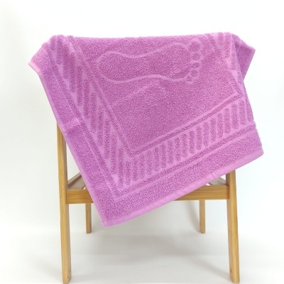 Toalha roxa com padrão de pegada pendurada em estrutura de madeira