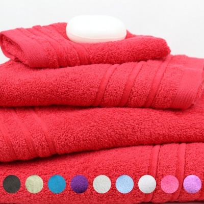 Toalhas vermelhas empilhadas com sabonete branco e círculos coloridos em baixo