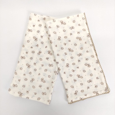 Fralda branca com padrão de pequenas flores castanhas e bordado castanho nas bordas