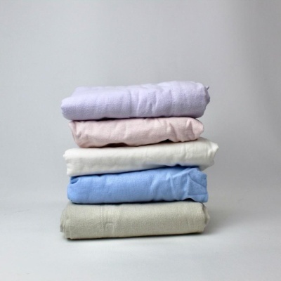 Cinco tecidos dobrados em cores suaves empilhados