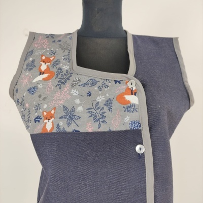 Roupa azul escuro com padrão de raposas e folhas, acabamento cinza claro e botões brancos.