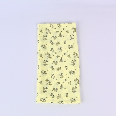 Pano amarelo com padrão de flores pequenas pretas e amarelas