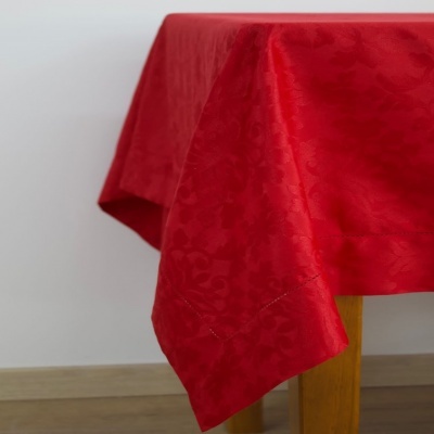 Toalha de mesa vermelha com padrão floral sobre mesa de madeira