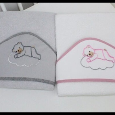 Duas toalhas de banho para bebé com bordado de urso a dormir numa nuvem, uma cinza e outra branca com bordas cor-de-rosa.