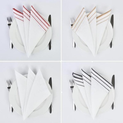 Guardanapos brancos com linhas coloridas em pratos e talheres