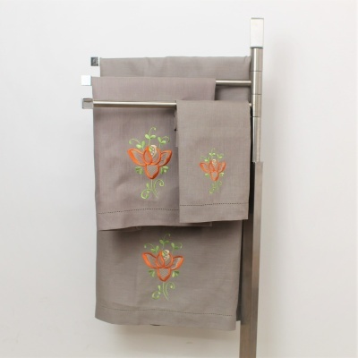 Conjunto de toalhas cinzentas com bordado floral penduradas em suporte metálico