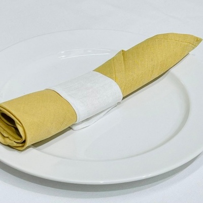 Guardanapo de tecido amarelo em prato branco