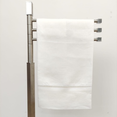 Toalha branca pendurada em suporte metálico