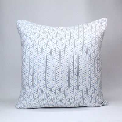 Travesseiro branco com padrão azul em fundo cinza claro