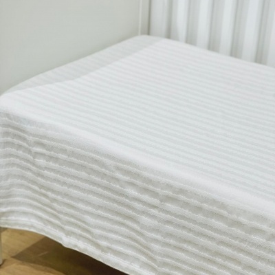 Capa de colchão branca riscada em berço branco