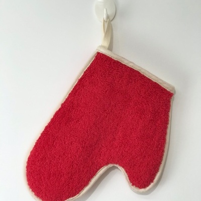 Luvas de cozinha felpudas vermelhas com borda bege penduradas num gancho branco