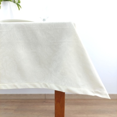 Toalha de mesa branca com padrão floral sobre mesa de madeira