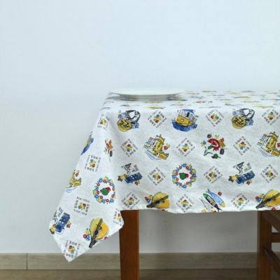 Toalha de mesa branca com estampados coloridos sobre mesa de madeira