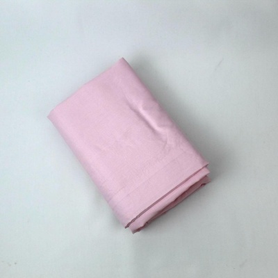 Lençol cor-de-rosa dobrado sobre superfície branca