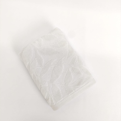 Toalha branca com padrão texturizado de folhas
