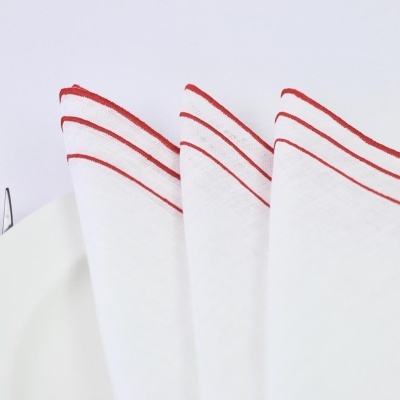 Três panos de cozinha brancos com linhas vermelhas e um prato branco