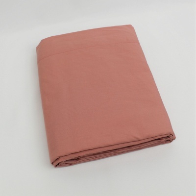 Lençol ou tecido cor de tijolo dobrado em superfície branca