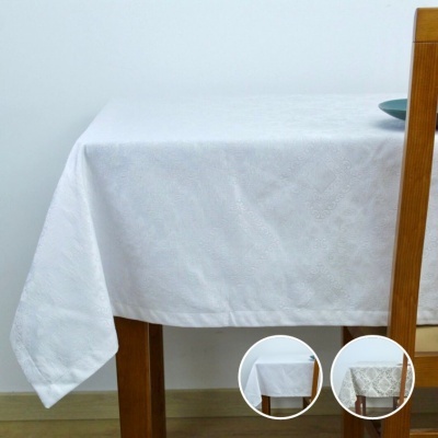 Toalha de mesa branca com padrão discreto sobre mesa de madeira